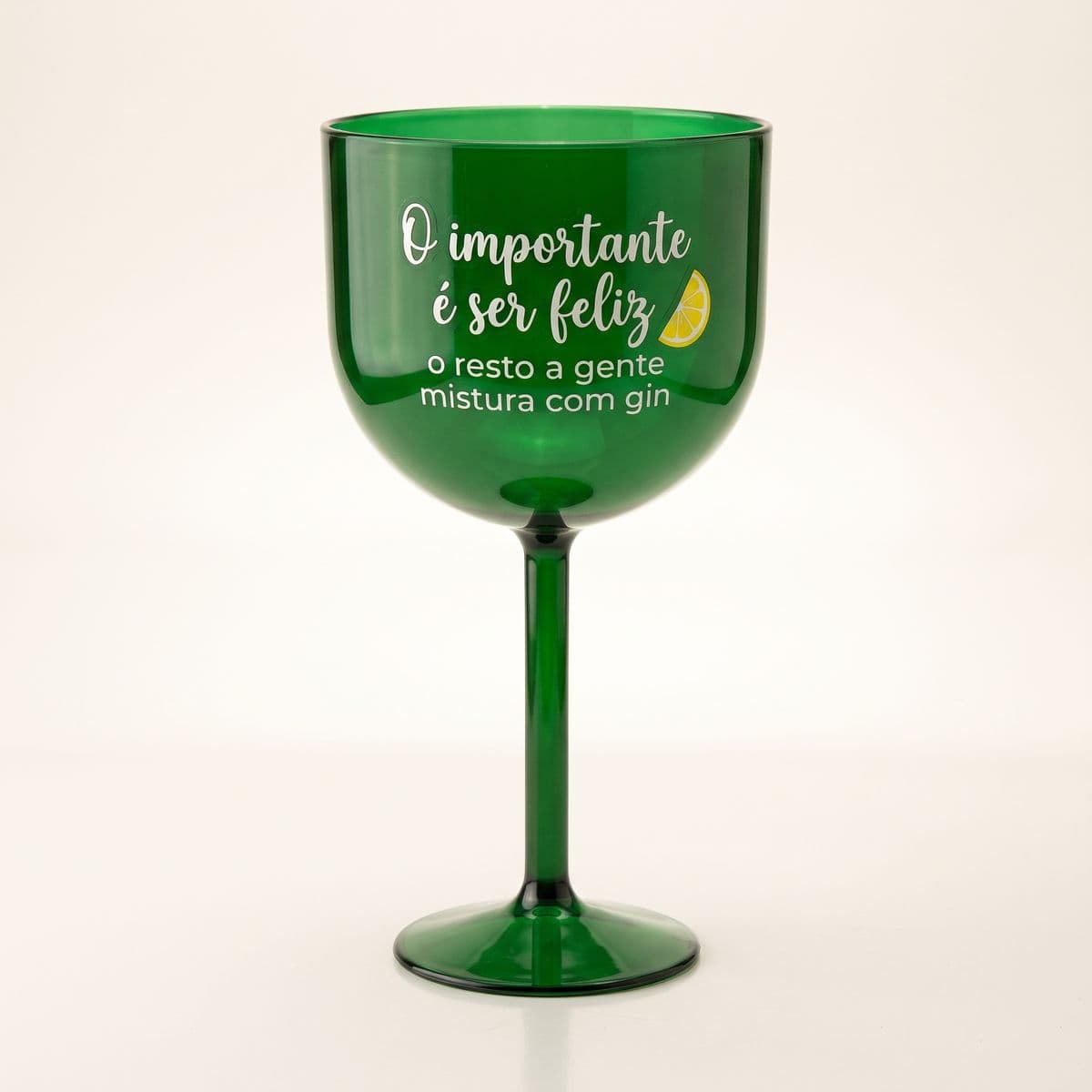 Taça de gin verde com a frase O importante é ser feliz, o resto a gente mistura com gin